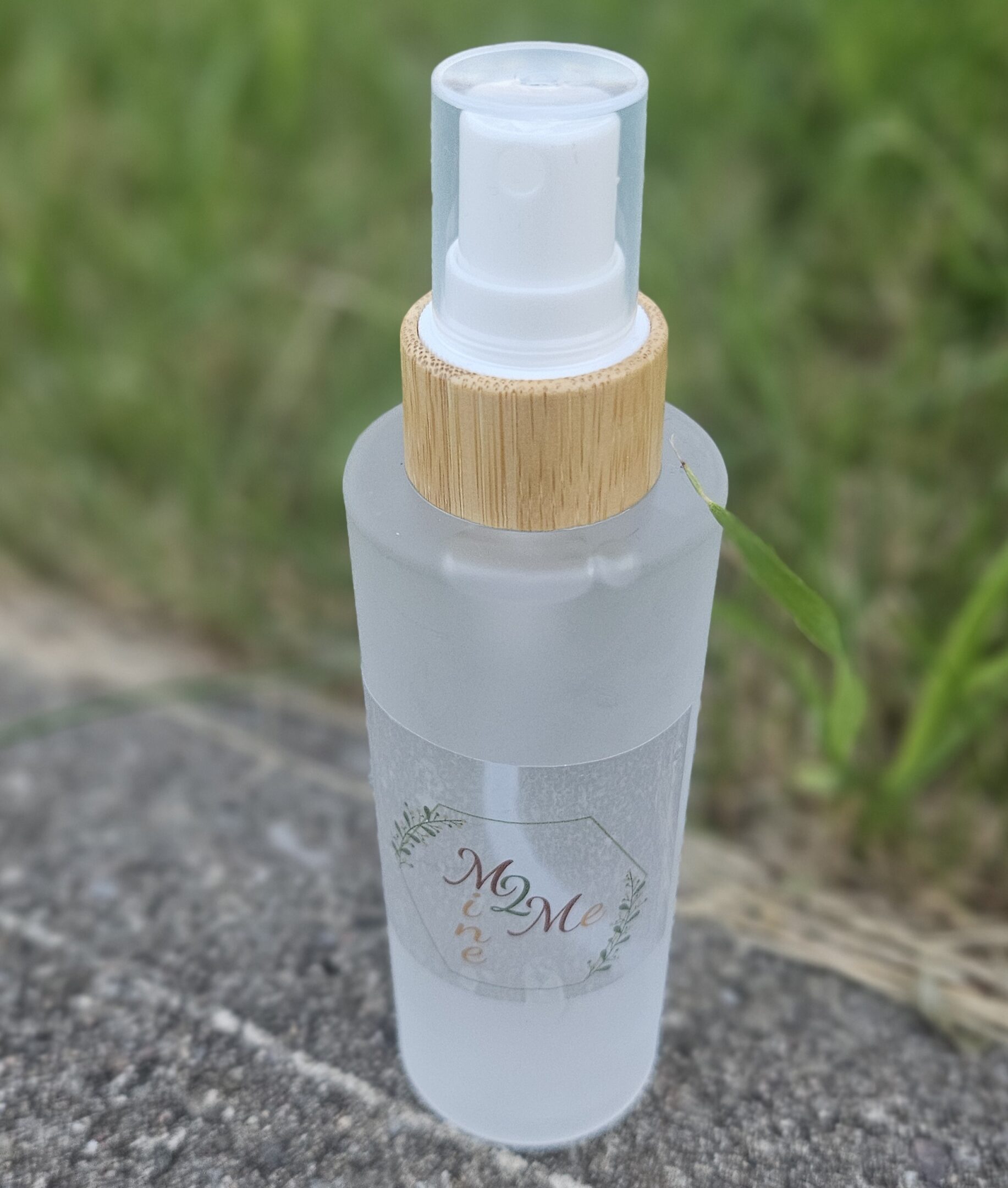 Frosted spray bottle on outdoor surface.