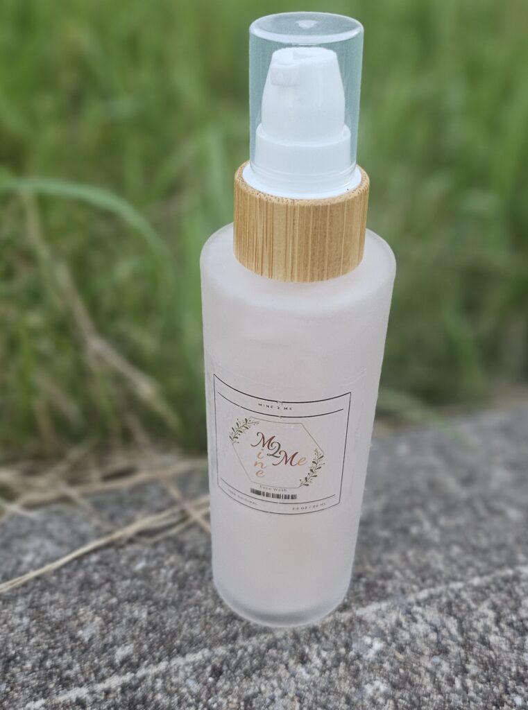 Frosted spray bottle with pump on ground.