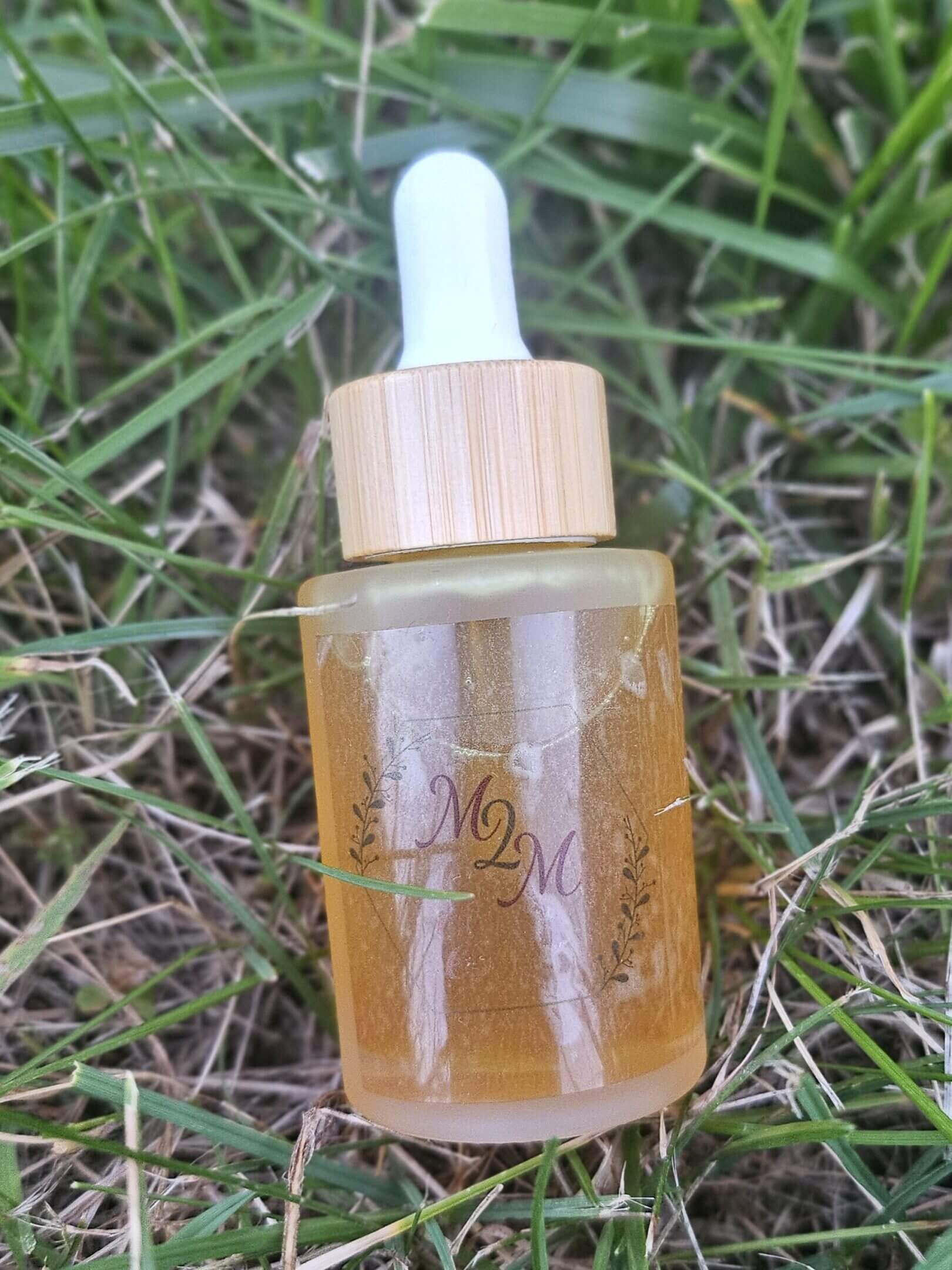 Dropper bottle on grass background.